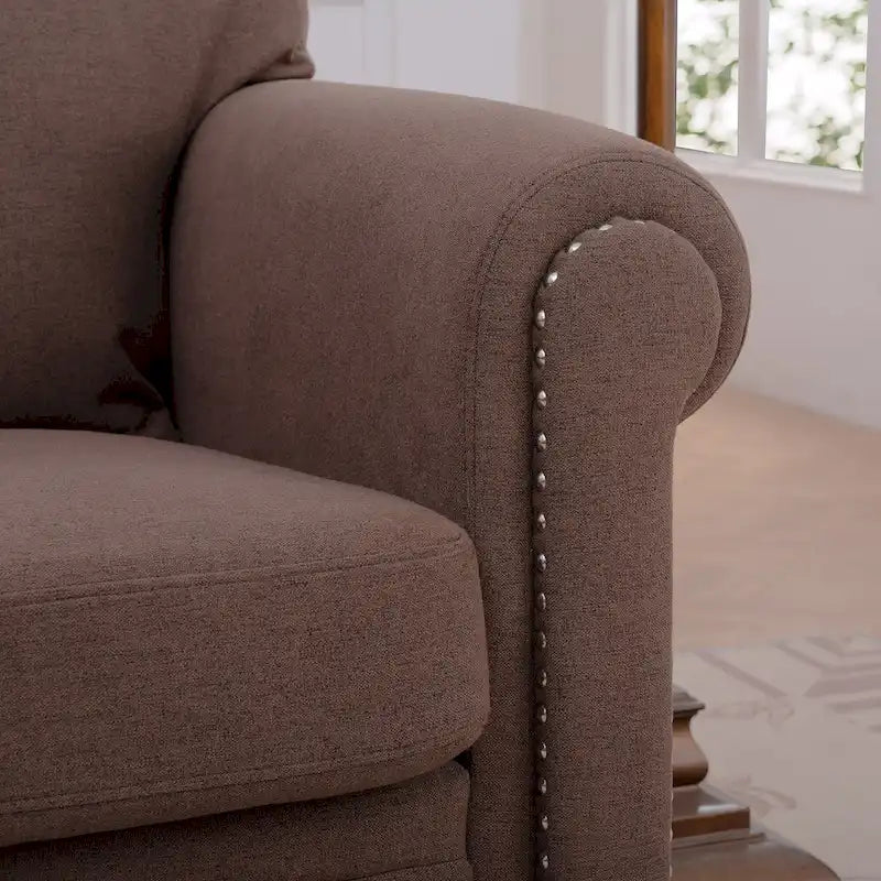 Sillón tapizado color café con brazos enrollados y tachuelas decorativas