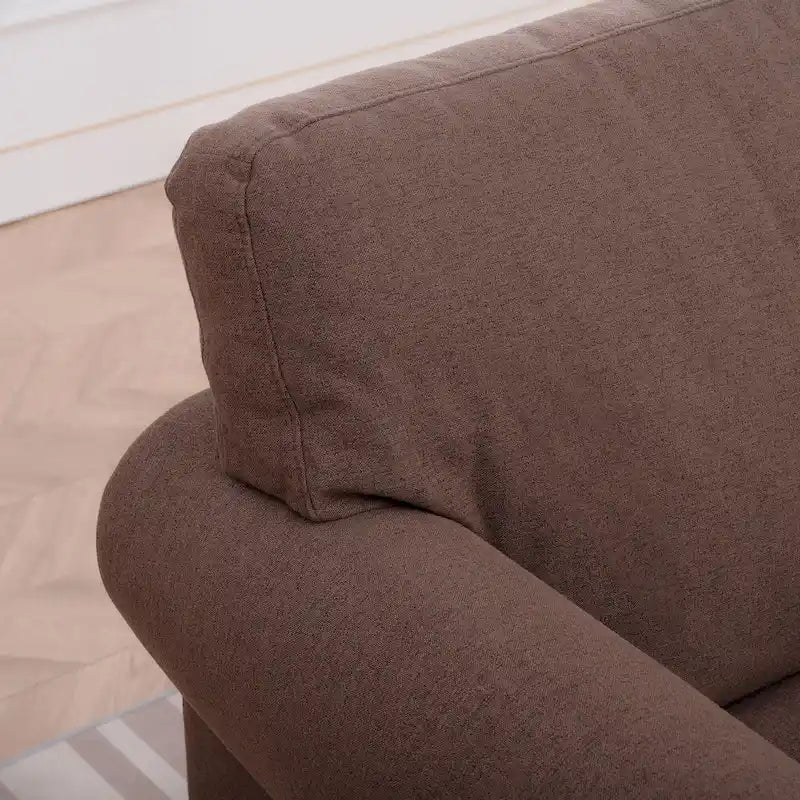 Sillón tapizado color café con brazos enrollados y tachuelas decorativas
