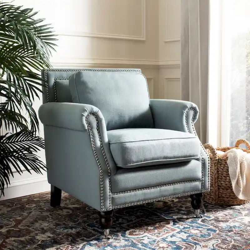 Sillón club clásico con reposabrazos enrollados y tachuelas